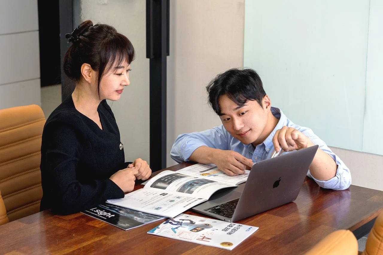 노트북과 교육 자료를 함께 살펴보는 드림베이스 구성원